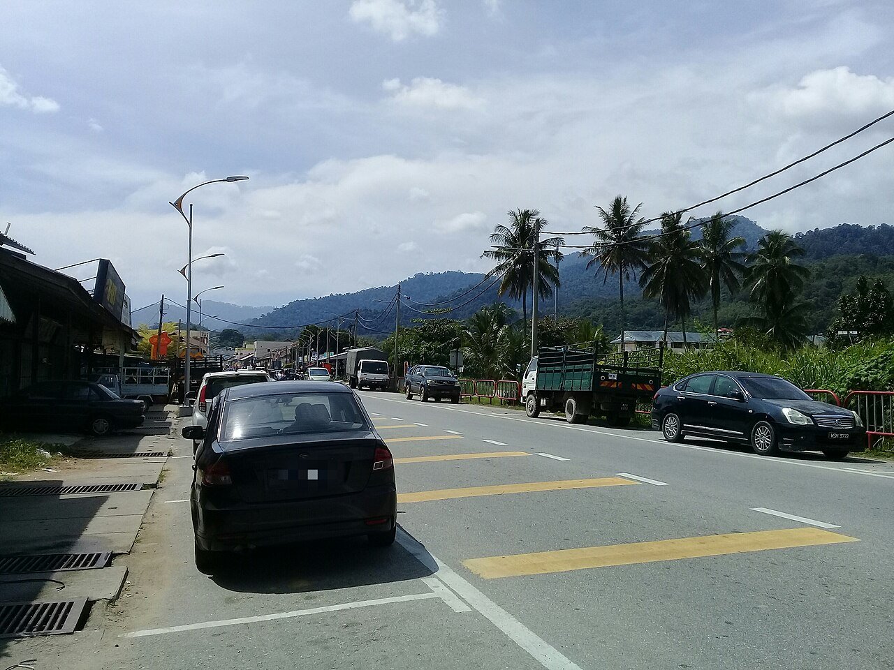Street scene in Lenggong town, Perak, with forested hills behind
