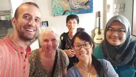 A cheerful group selfie by travellers staying at Sojourn Beds & Cafe in Taiping