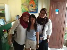 Three guests sharing a cheerful moment inside Sojourn Beds & Cafe in Taiping
