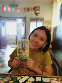A guest holding a Sojourn illustrated postcard during their stay in Taiping