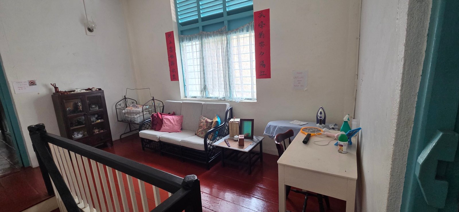 Shared upstairs lounge with wooden floor and chairs inside Sojourn Beds & Cafe, Taiping